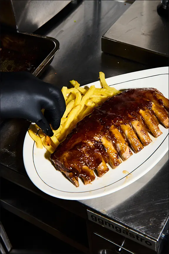 Auténticas BBQ Ribs estilo americano en Madrid con guarnición de patatas.