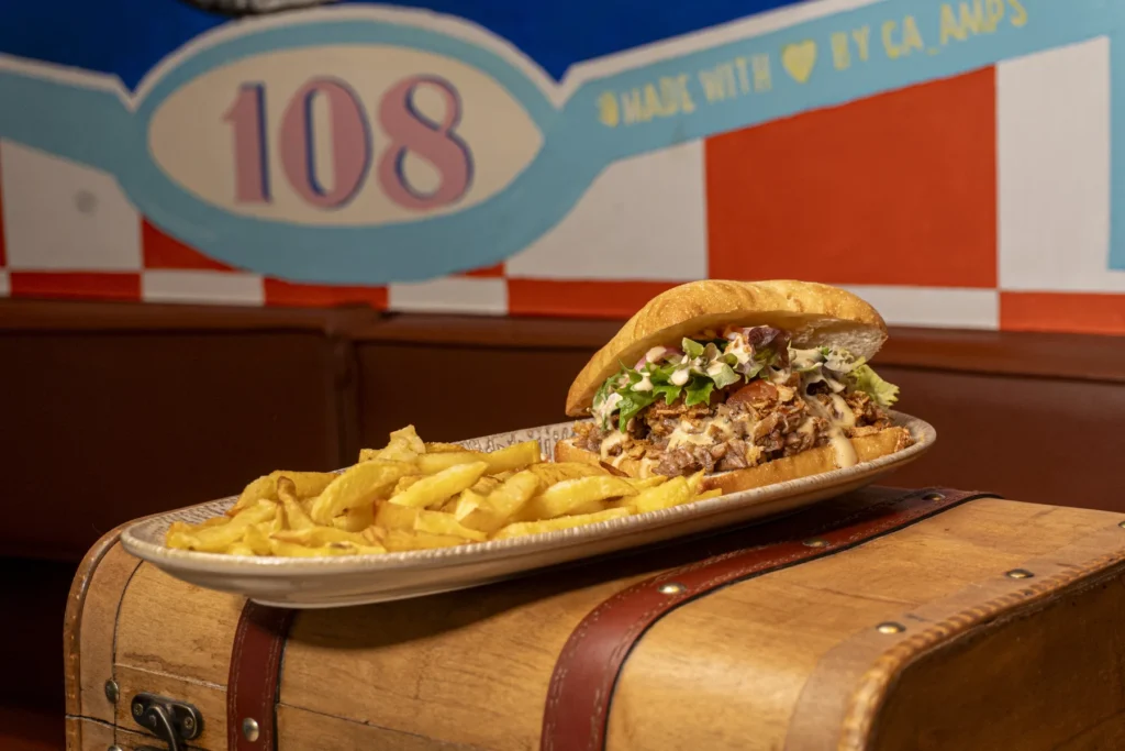Bocata de costilla de Alright con salsa y guarnición, restaurante americano en Madrid.